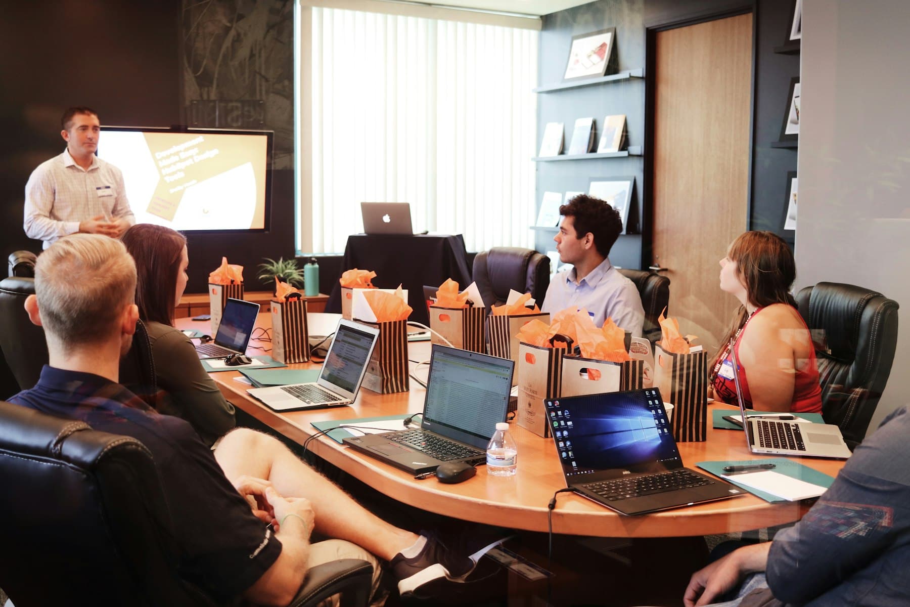 An instructor presenting to colleagues at laptops, the build-then-teach format of an AI faculty development programme