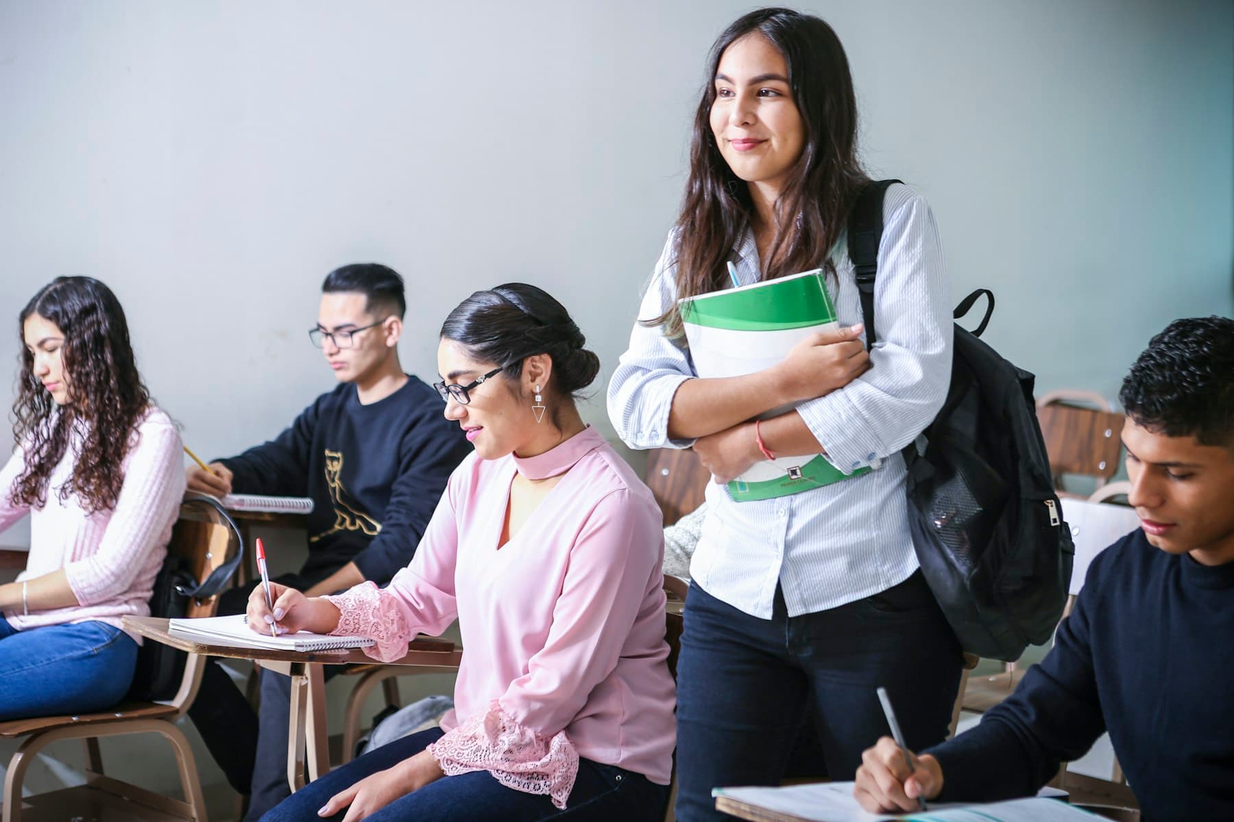 College students writing in a bright classroom, where AI programmes for colleges begin: one department first