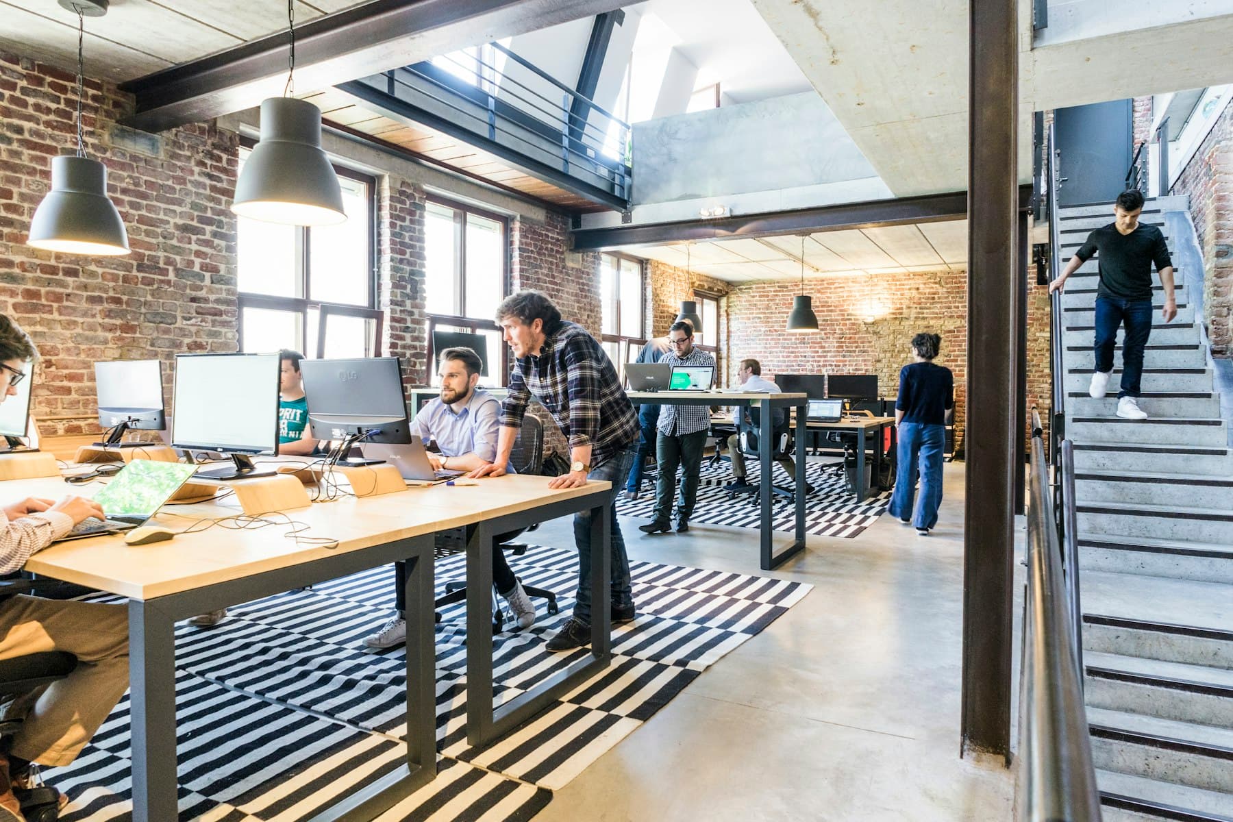 A startup team at work in a bright brick-walled coworking space, deciding where AI for startups and MSMEs should go first