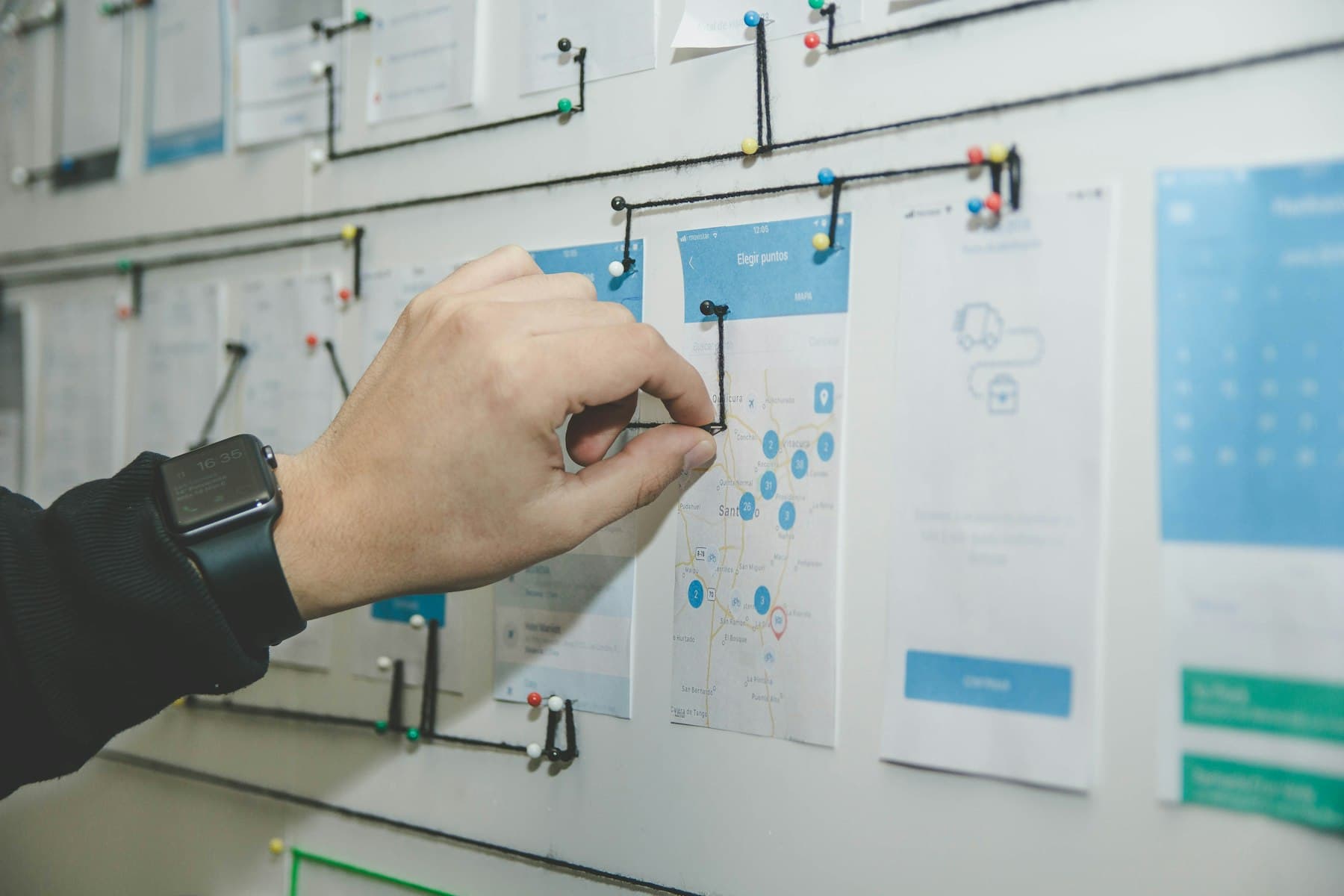 A hand pinning a card to a project planning board while mapping AI use cases by industry