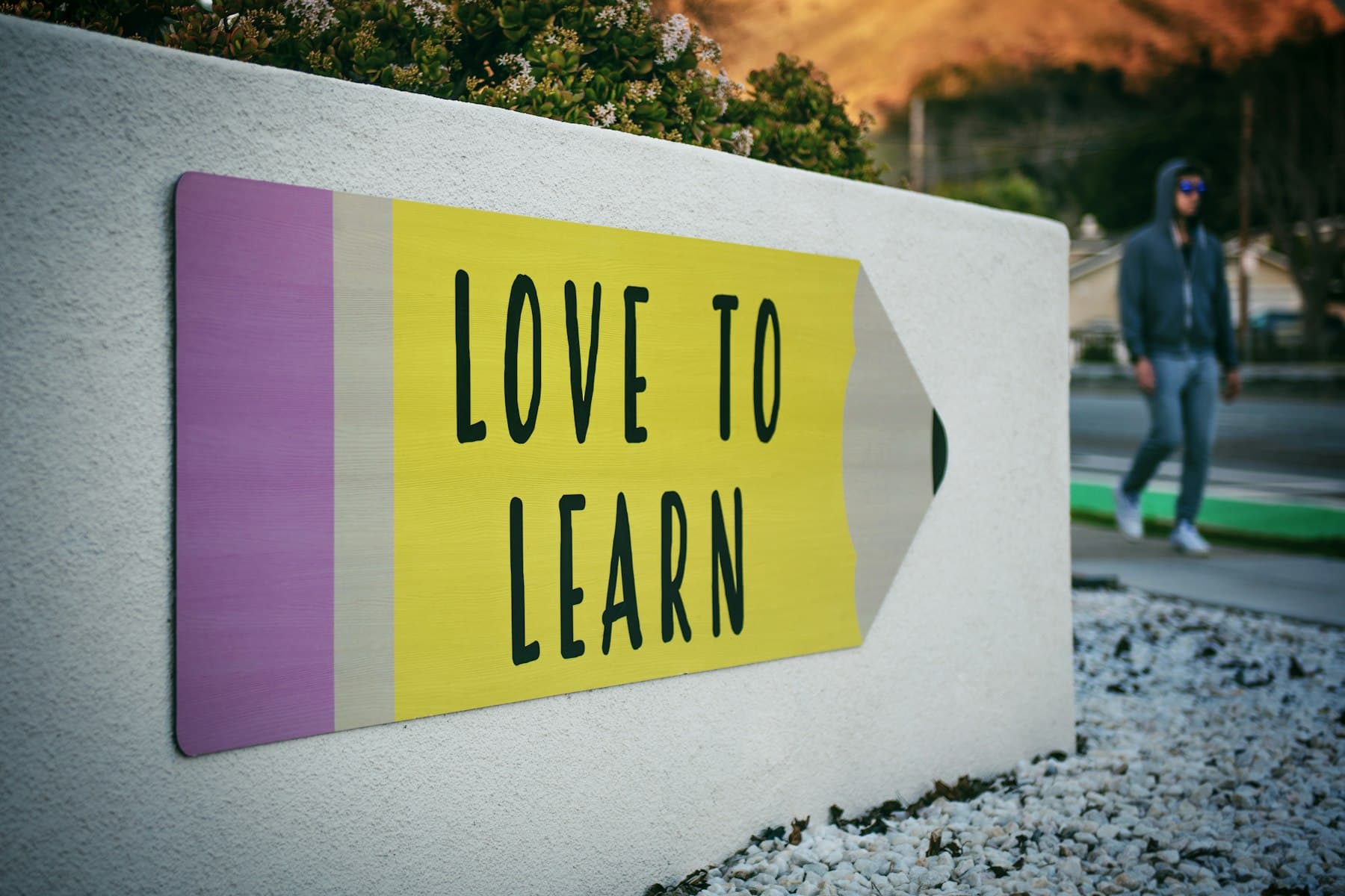 Pencil-shaped sign reading “Love to learn”