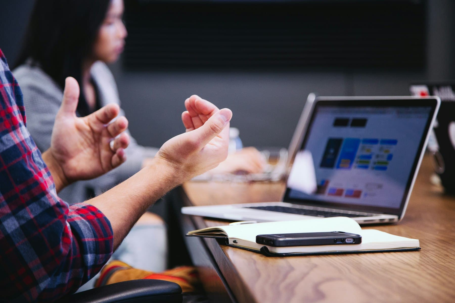 Hands gesturing over a laptop during a workshop